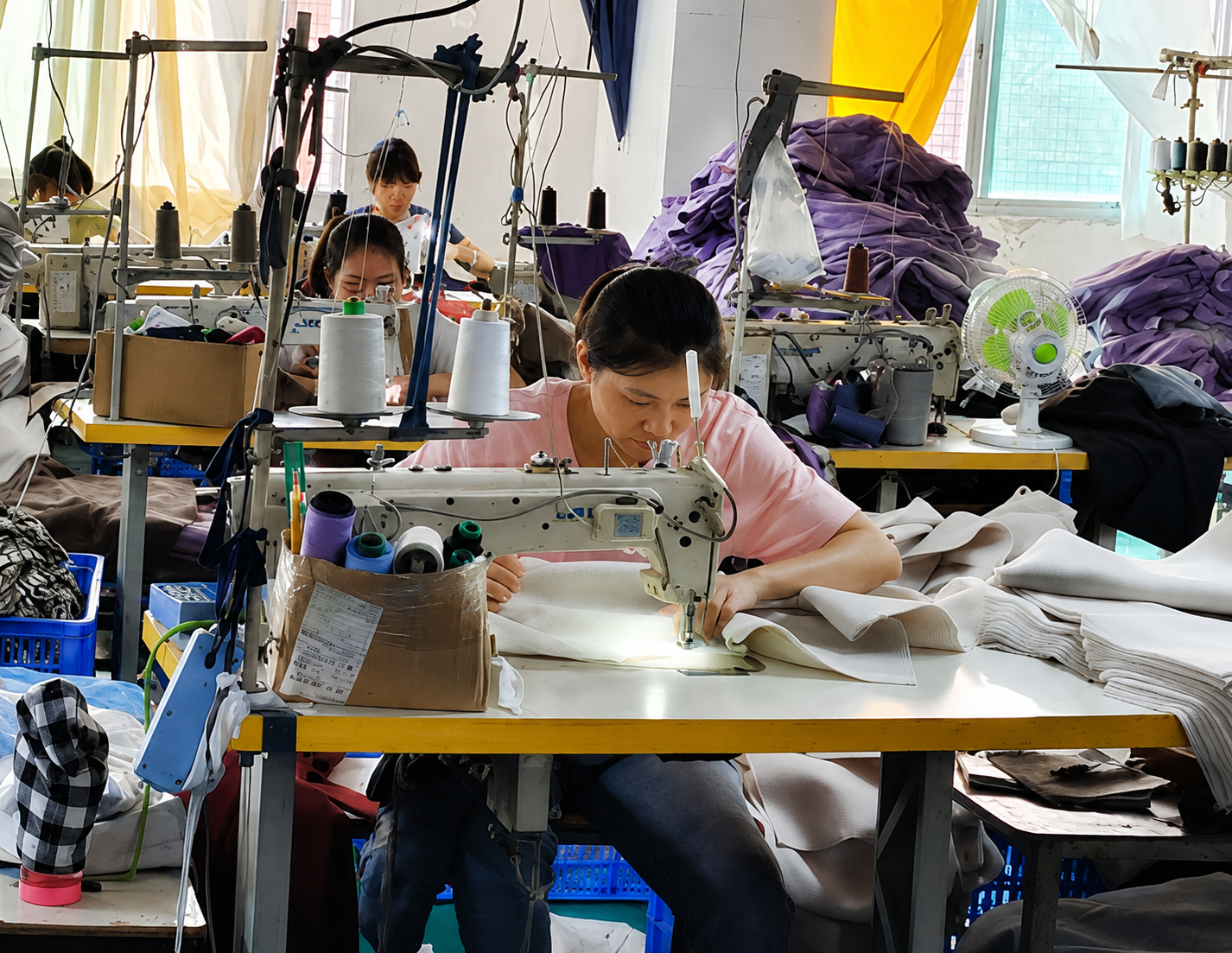 Garment production team sewing women’s clothing in an apparel workshop