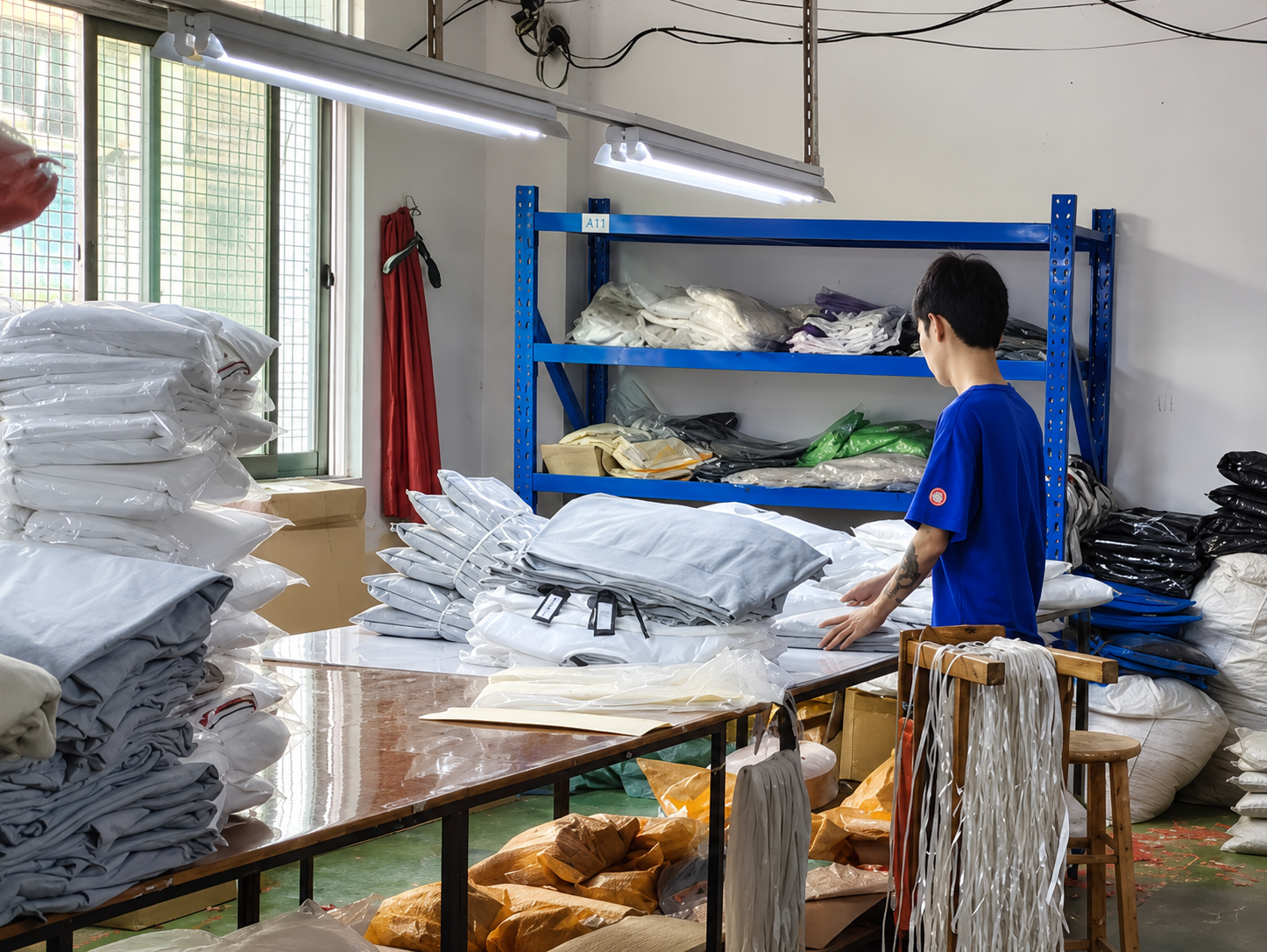 Team member organizing and inspecting packaged garments before shipment